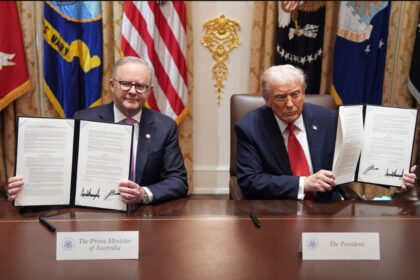 Anthony Albanese and Donald Trump holding signed critical minerals agreement at White House.