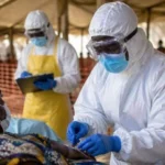 Healthcare worker wearing protective equipment during an Ebola outbreak response in Africa.